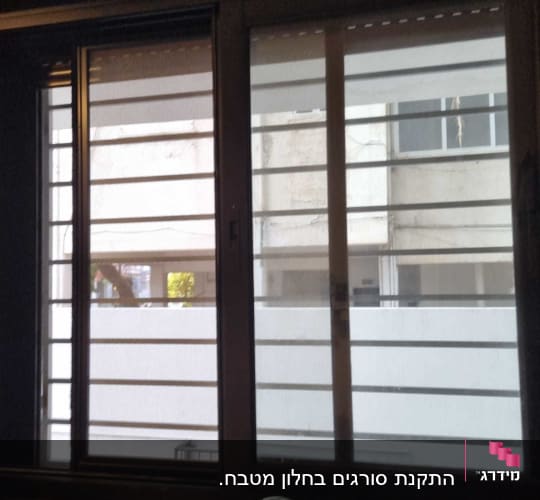 חלון עם מסגרת מתכת וברז בחזית